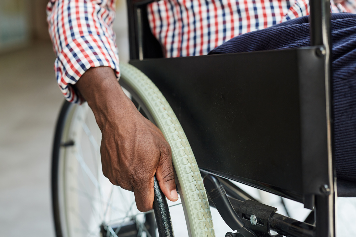 a person in a wheelchair with their hand on the wheel